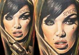 Woman with gun tattoo by Sergey Shanko